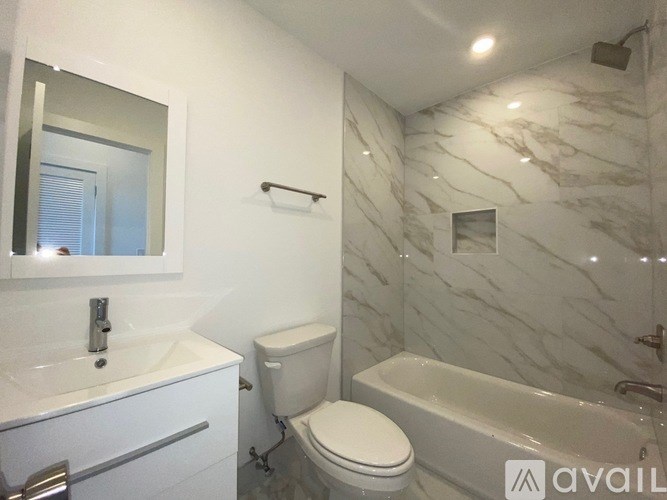 A bathroom with a marble wall and a white toilet.