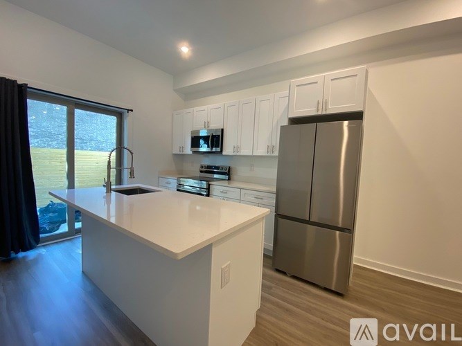 A kitchen with white cabinets and a stainless steel refrigerator.