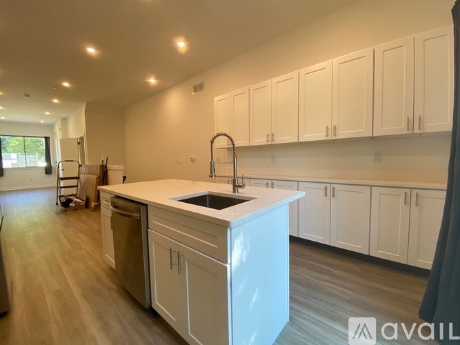 A kitchen with white cabinets and a sink.