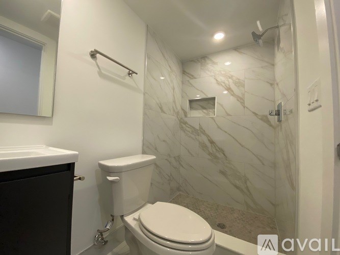 A white toilet in a bathroom with marble tiles.