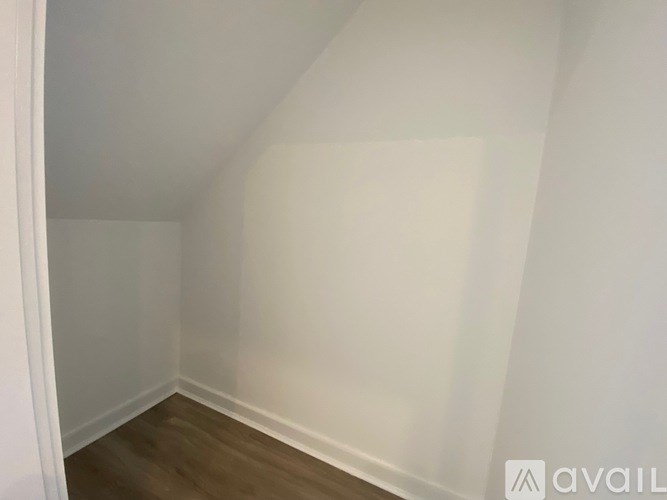 A room with white walls and wooden flooring.