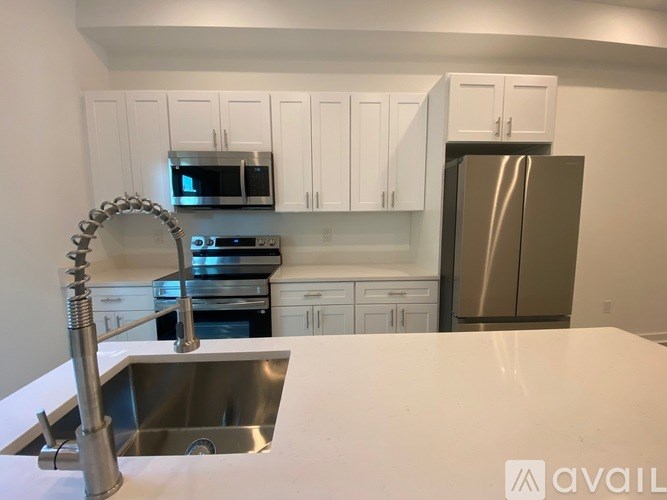 A kitchen with a stainless steel refrigerator, microwave, oven, and sink.