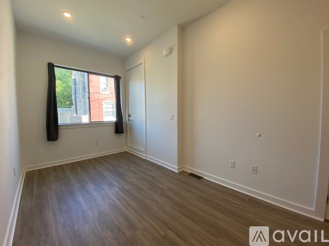 A room with a window and wooden flooring is available for rent.