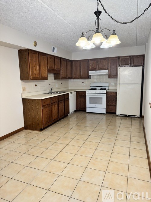 A kitchen with white appliances and wooden cabinets.