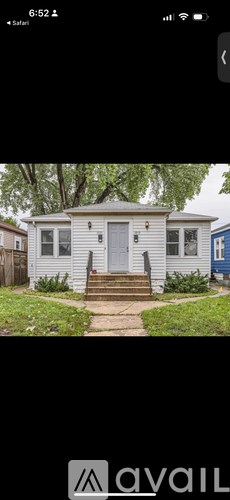 A small house with a grey door and steps leading up to it.