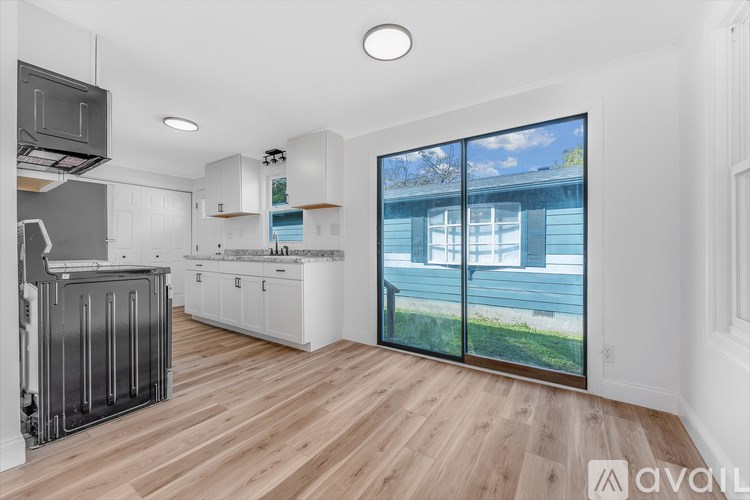 A kitchen with white cabinets and a wooden floor.