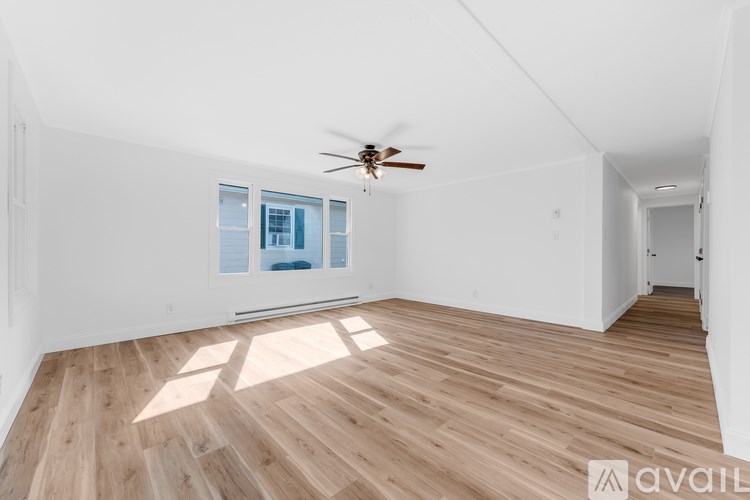 A room with wooden flooring and a ceiling fan.