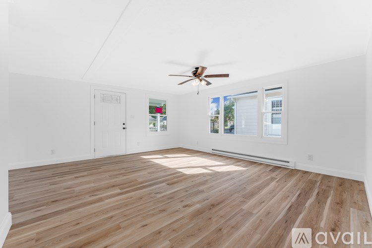 A room with wooden flooring and a ceiling fan.