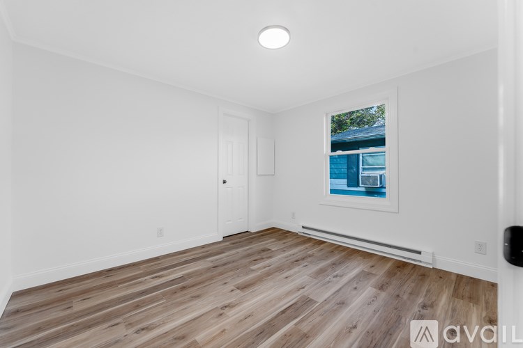 A room with wooden flooring and a picture on the wall.