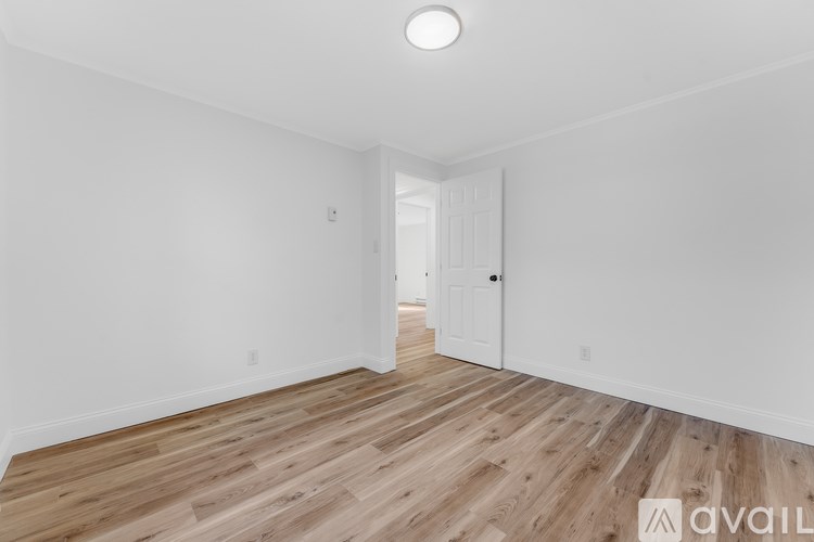 A room with wooden flooring and white walls.