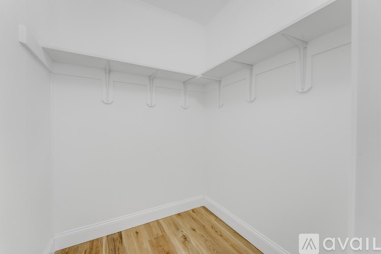 A white wall with a row of white pipes on it.
