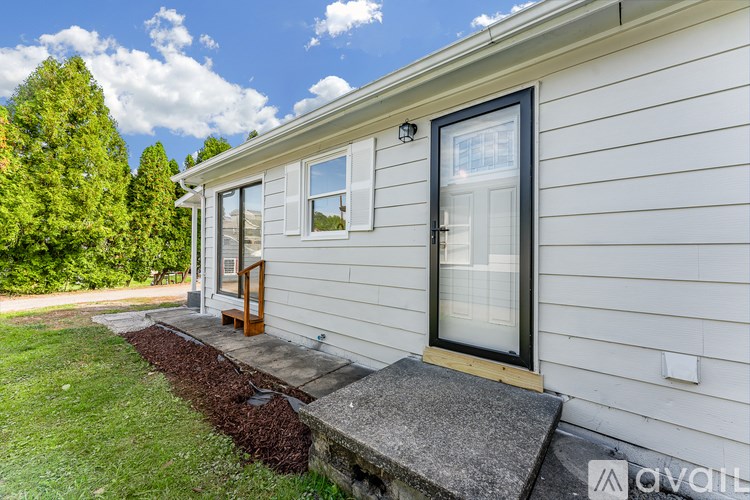 A house with a white exterior and a black door is shown.