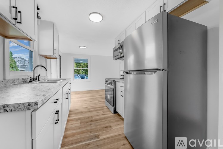 A modern kitchen with a large refrigerator and wooden flooring.