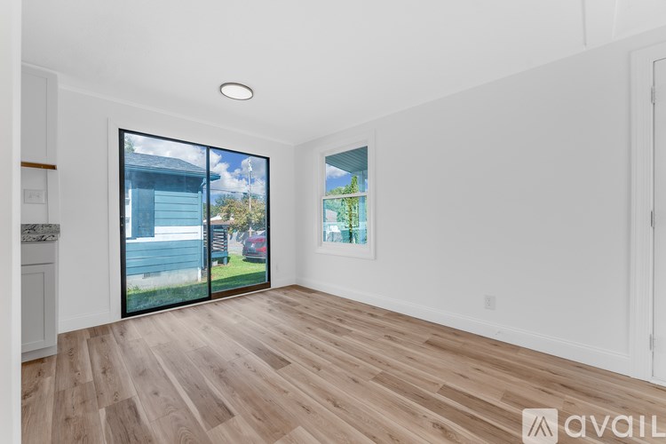 A room with wooden flooring and a painting on the wall.