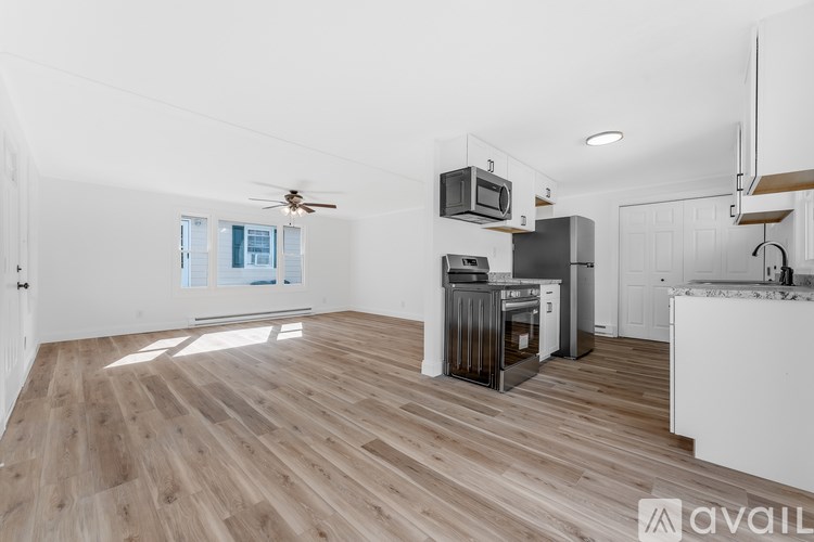 A kitchen with a wooden floor and white walls.