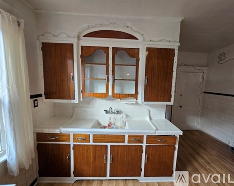A kitchen with wooden cabinets and a white sink.