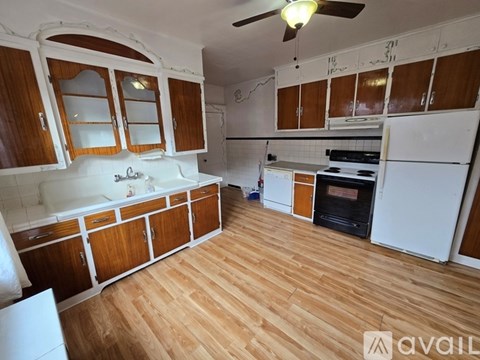 A kitchen with wooden cabinets and a white fridge.