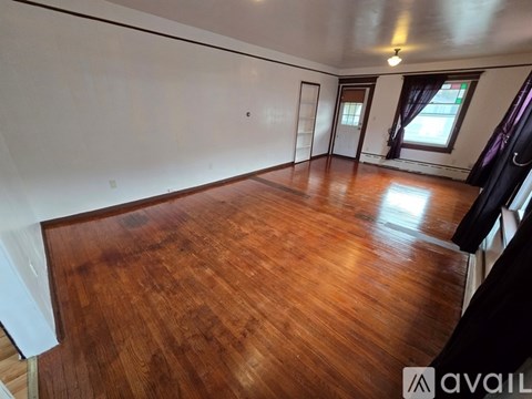 A room with wooden flooring and white walls.