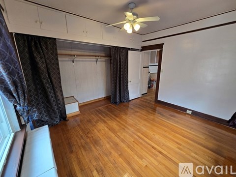 A room with wooden flooring and a ceiling fan.