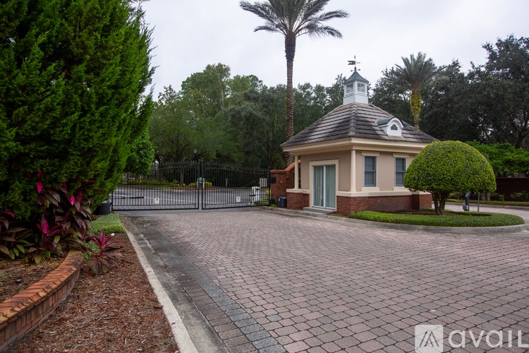 A small house with a black fence and a palm tree in front.