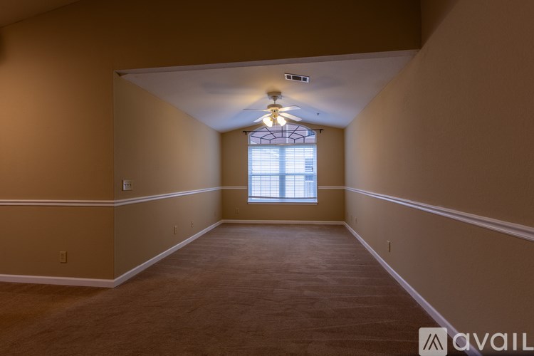 A room with a carpeted floor and a window with blinds.