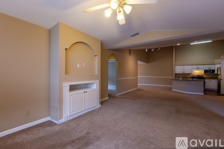 A living room with a fireplace and a ceiling fan.