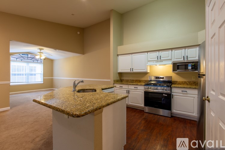 A kitchen with a granite countertop and stainless steel appliances.