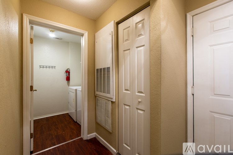 A hallway with a white door on the left and a white door on the right.