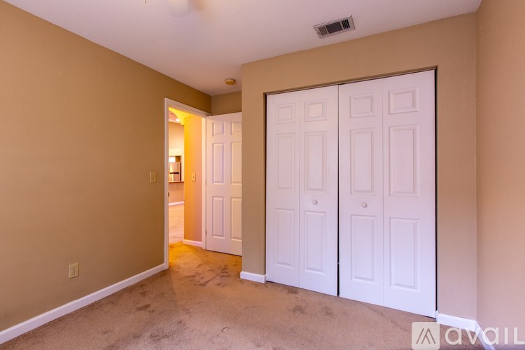 A room with a white door and a carpeted floor.