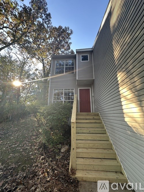A house with a red door and a wooden staircase leading to it.