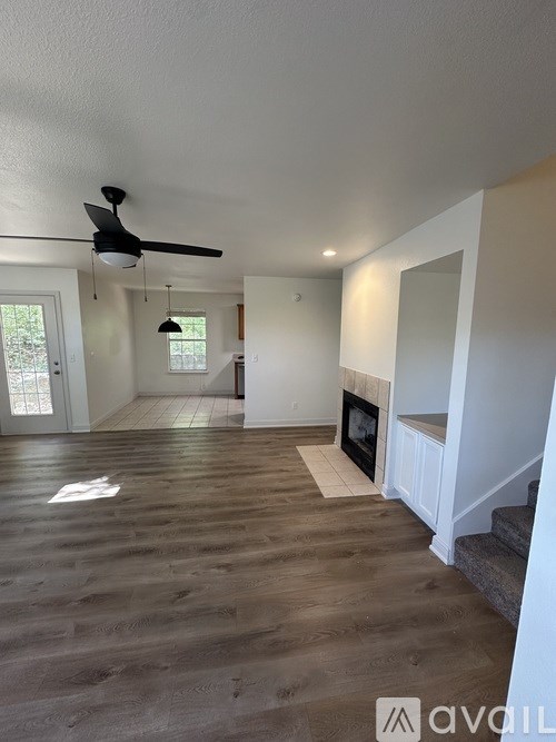 A room with a fireplace and a fan on the ceiling.