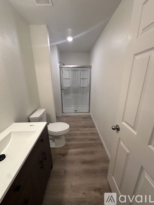 A bathroom with a toilet, sink, and shower.