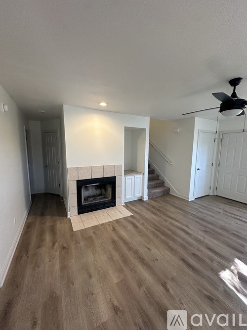 A living room with a fireplace and a staircase.