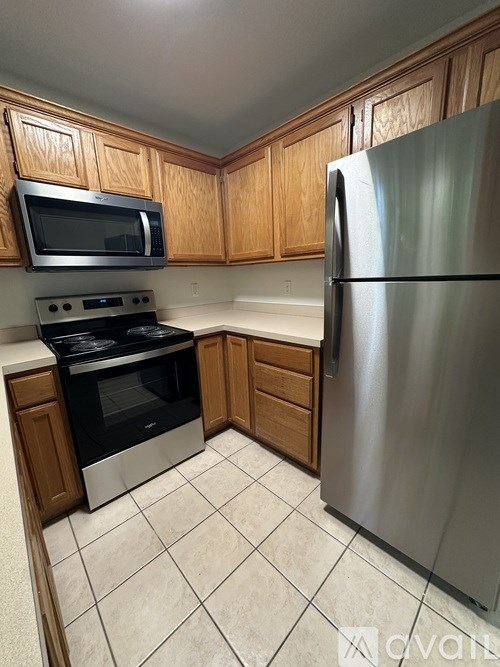 A kitchen with a stainless steel refrigerator, microwave, and oven.