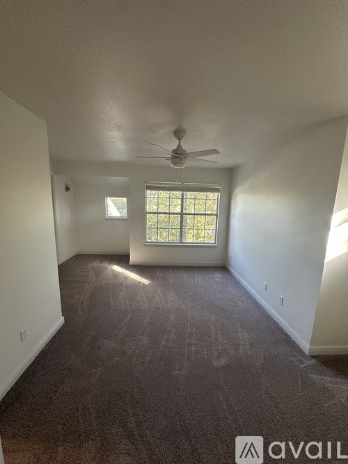 A room with a ceiling fan and a window.