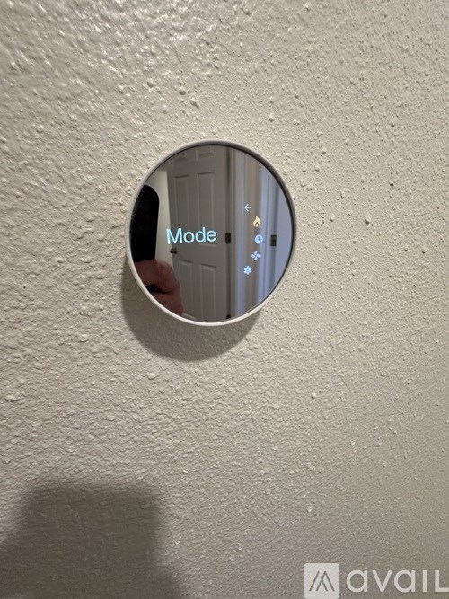 A round mirror with the word Mode written on it.