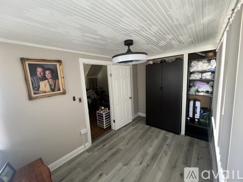 A room with a white ceiling and a painting on the wall.