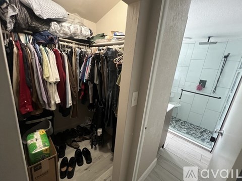 A small closet with clothes and shoes.