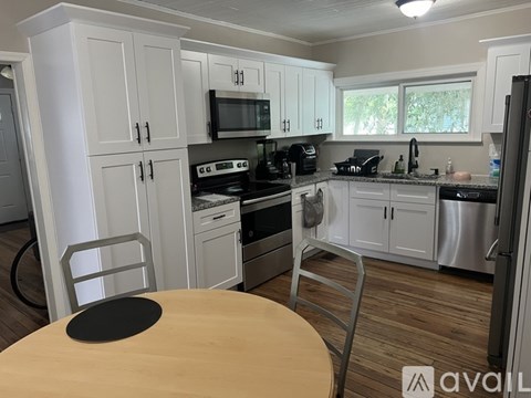 A kitchen with white cabinets and a wooden table.