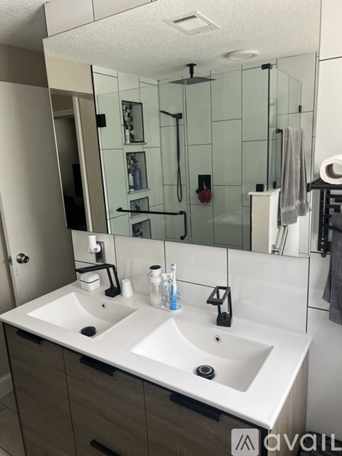 A bathroom with a white countertop and a large mirror above it.