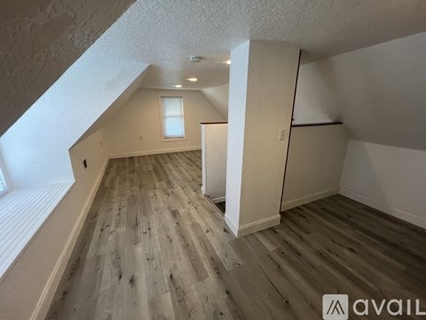 A room with wooden flooring and white walls.