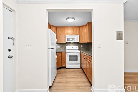 A kitchen with wooden cabinets and white appliances.