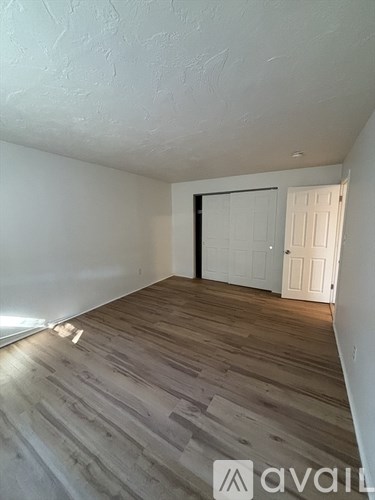 A room with wooden flooring and a white door.