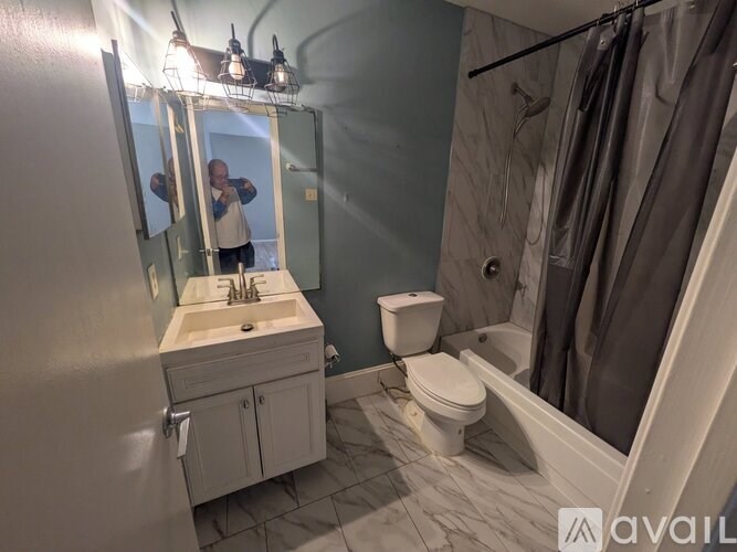 A man is taking a picture of a bathroom in a mirror.