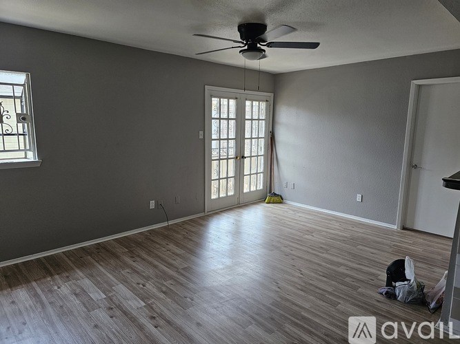 A room with a ceiling fan and a window with blinds.