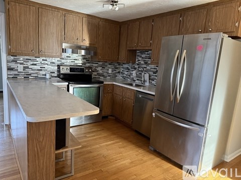 A kitchen with a refrigerator, microwave, and stove.