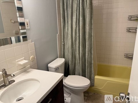 A bathroom with a sink, toilet, and shower.