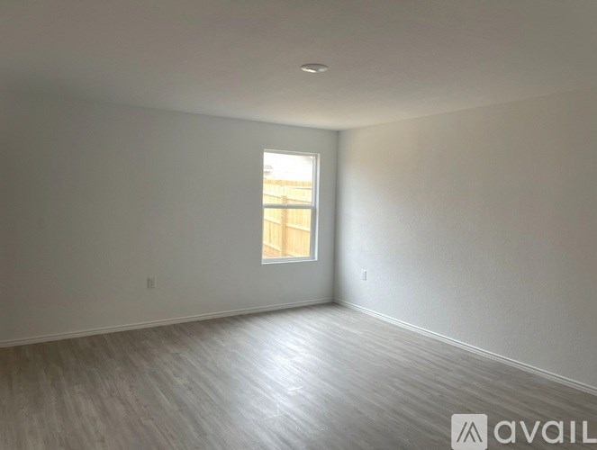 A room with a window and wooden flooring is available for rent.