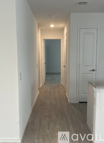 A hallway with a white door and a white cabinet.