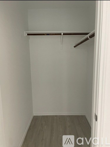 A white wall with a wooden floor and a white door.